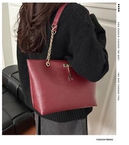 Détail du grand sac cabas bordeaux avec chaîne dorée et pendentif cerf sur le modèle