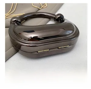 Detail shot of the durable metal bottom and elegant gold chain strap on the evening bag