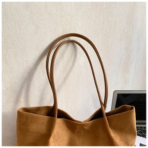 Detail of brown suede tote bag featuring fine vertical stitching and long shoulder straps