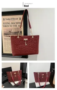 Detail of red leopard print tote bag with golden chain strap and deer pendant