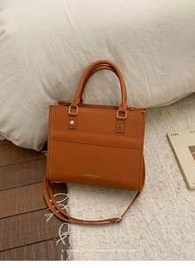 Detail of caramel faux leather tote bag with pebble texture and adjustable shoulder strap