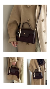 Detail view of brown leather crossbody bag with beaded charm and adjustable strap