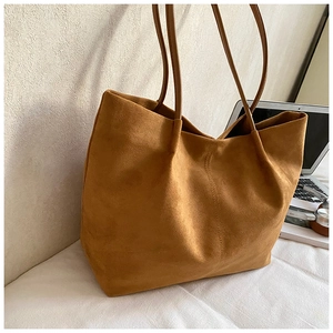 Detailed view of brown suede tote bag featuring a spacious interior and long handles