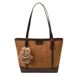 Brown embossed tote bag with cat patterns and plush puppy charm on white background