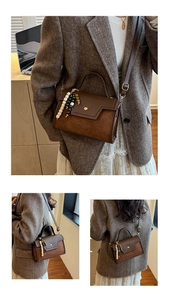 Close-up of vintage brown baguette bag with mixed textures and decorative beads