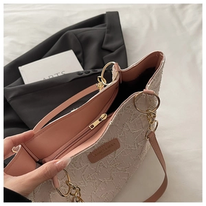 Close-up of lace tote bag interior with pink leather lining and golden zipper detail