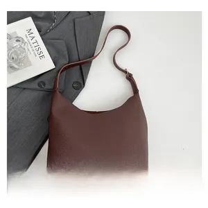 Macro view showing the lychee grain texture and minimalist design of this dark brown tote bag