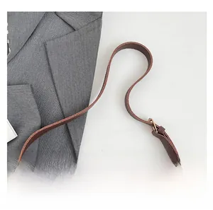 Detail of brown litchi pattern leather bag showing gold buckle and stitching