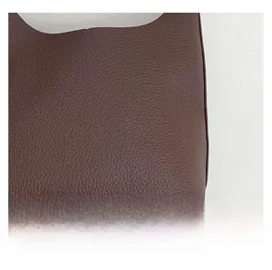 Detailed close-up of dark brown lychee grain leather texture on a fashion tote bag