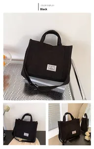 Detail view of black corduroy tote bag with adjustable strap and minimalist white label