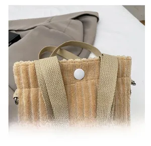 Detail view of khaki corduroy mini bag with a round button and textured shoulder strap