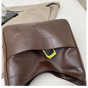 Detailed view of woven brown leather tote bag featuring a practical front outer pocket