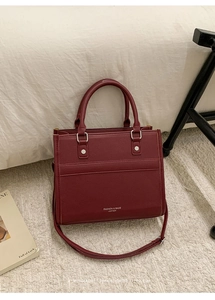 Detailed macro view of retro burgundy litchi grain leather bag with silver studs