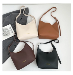 Flat lay of four matte textured crossbody lunch-style bags in various elegant colors