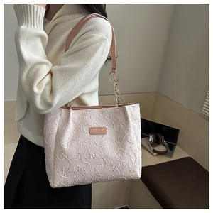 Dettaglio della borsa tote rosa testurizzata con elegante catena dorata e pelle