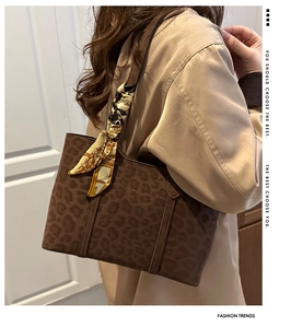 Gros plan sur un sac fourre-tout léopard marron avec ruban de soie décoratif au manche