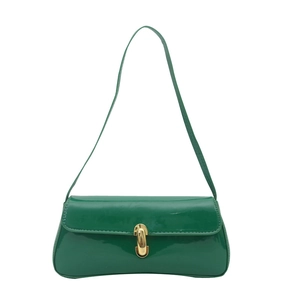 Sac sous le bras en cuir vert brillant avec boucle dorée sur fond blanc propre