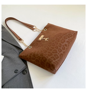 Detail of leopard print tote bag with gold deer pendant and chain leather strap