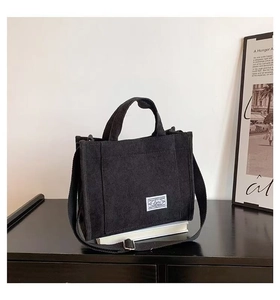 Detail of black corduroy tote bag with Lolu label and adjustable shoulder strap