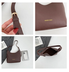 Detail of minimalist brown tote bag showing leather texture, golden buckle and interior capacity