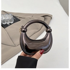 Detail of a dark grey metallic hobo bag with integrated ring handle and metal chain