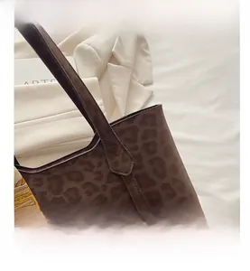 Détail du sac cabas léopard avec foulard en soie décoratif sur un blazer de couleur crème
