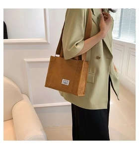 Detail of caramel brown corduroy tote bag featuring striped texture and fabric label