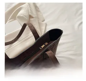 Détail d'un sac cabas à imprimé léopard avec fermeture éclair et garnitures dorées