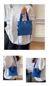 Detail of blue corduroy mini handbag showing ribbed texture and white snap button closure