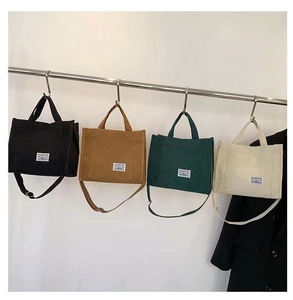 Detailed view of four corduroy tote bags in black, caramel, green, and beige colors