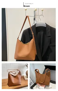 Detail of brown litchi pattern leather tote bag with gold stamped logo and strap