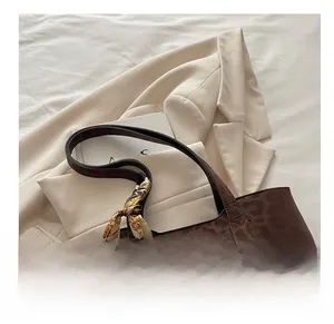 Détail du sac cabas marron à motif léopard avec un foulard floral en soie sur l'anse