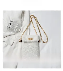 Detail showing white faux shearling crossbody bag with gold chain strap and metal lock