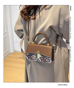 Close-up of leopard print patchwork and gold metal clasp on a vintage brown bag