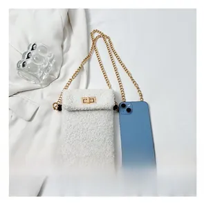 Faux fur mobile phone bag with golden chain and lock shown next to a smartphone