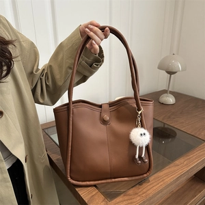 Brown vintage faux leather tote bag with a cute plush monster charm and magnetic closure