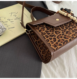 Détail du sac à main vintage léopard avec breloques en perles de bois et fermoir magnétique doré