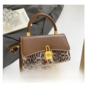Detail of a brown leather and leopard print handbag featuring a gold padlock closure