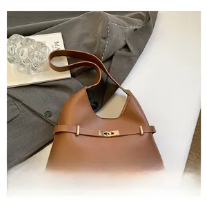 Dettaglio della borsa tote in pelle marrone caramello con fibbia in metallo dorato