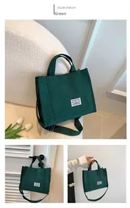 Detailed view of green corduroy tote bag showing side strap and hand-carry handles
