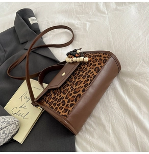 Sac à main marron imprimé léopard avec poignée en perles sur lin et blazer gris