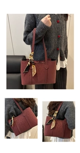Detail of burgundy leopard embossed leather tote bag featuring decorative floral scarf handle