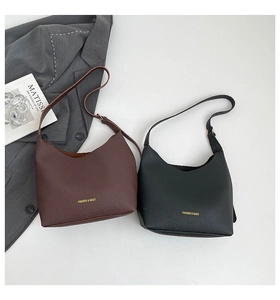 Detail of lychee pattern leather shoulder bags in black and brown with gold logo