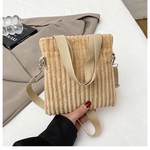 Detail view of beige corduroy mini tote bag texture with adjustable strap and top handles
