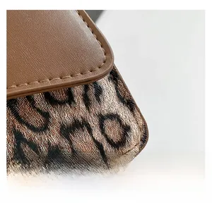Detail of premium leopard print faux fur and brown leather stitching on a small square bag