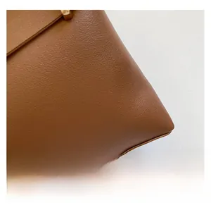 Dettaglio della trama in pelle marrone premium con cuciture rifinite e inserti metallici