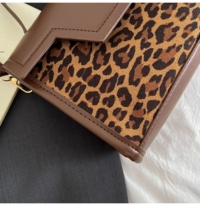 Close-up of retro leopard print patchwork on brown leather flap square bag with detailed stitching