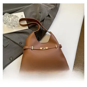 Dettaglio di borsa tote vintage in pelle marrone con fibbia dorata e stile minimalista