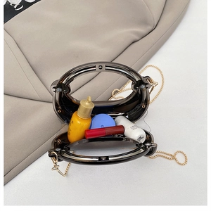 Detail view of transparent brown acrylic handbag capacity with golden chain strap