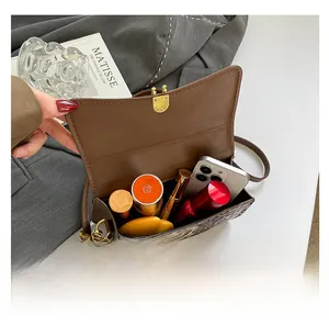 Detailed internal view showing capacity for smartphone and cosmetics in leopard print bag